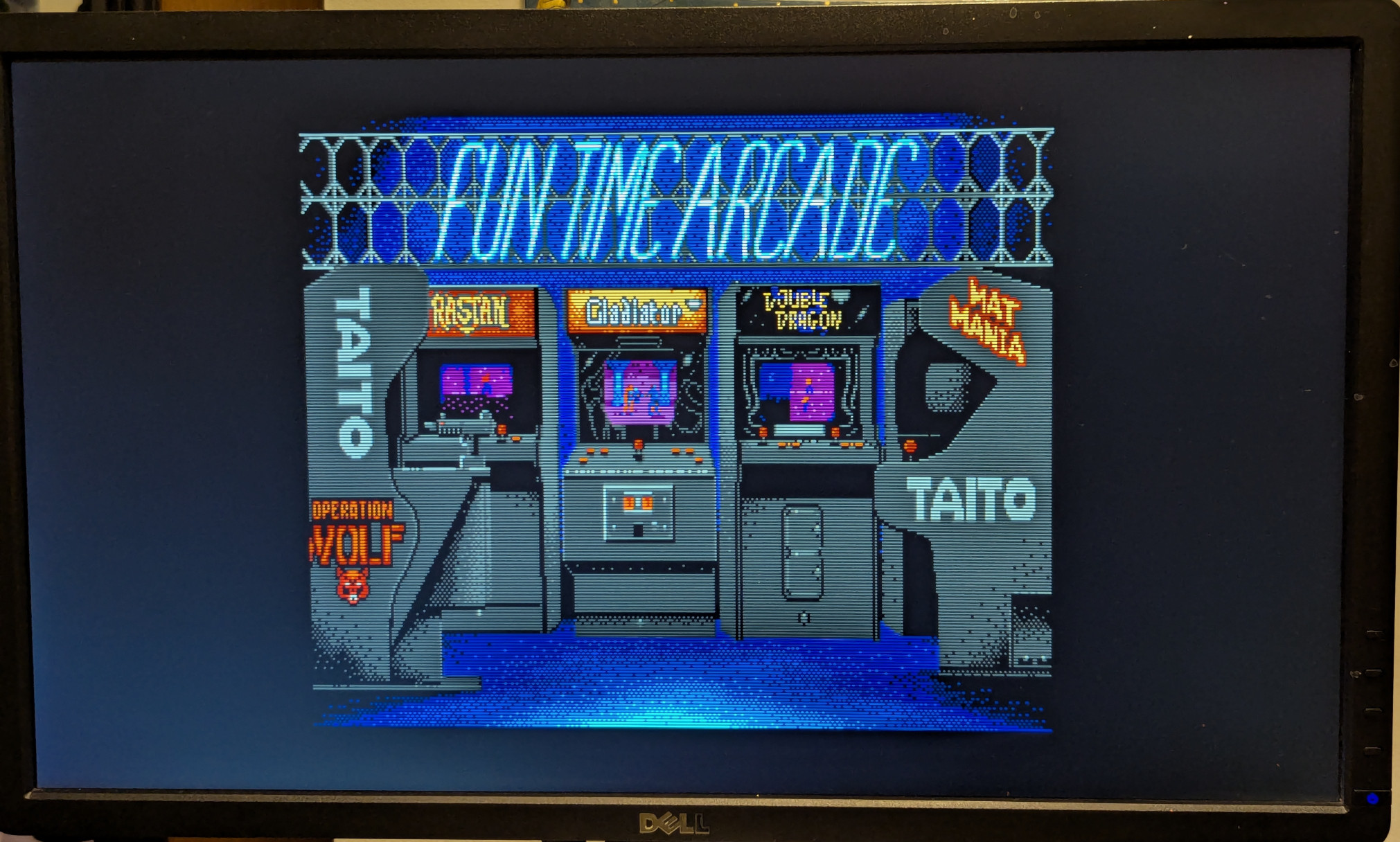 A photograph of a loading screen from an Apple IIgs game.  The screen is from a Taito game, a port from their arcade cabinets to home PCs.  The image is an artistic rendering of a 'Fun Time Arcade', wih arcade cabinets for Operation Wolf, Rastan, Gladiator, Double Dragon, and Mat Mania.