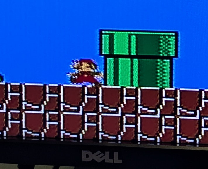 A zoomed-in photo of Super Mario Bros for the Nintendo Entertainment System, displayed on a Dell LCD monitor.  Mario's pixels look weirdly irregular and fuzzy, an artifact of the monitor's scaler circuitry trying to drag the video standards of 1985 forward into the present day.