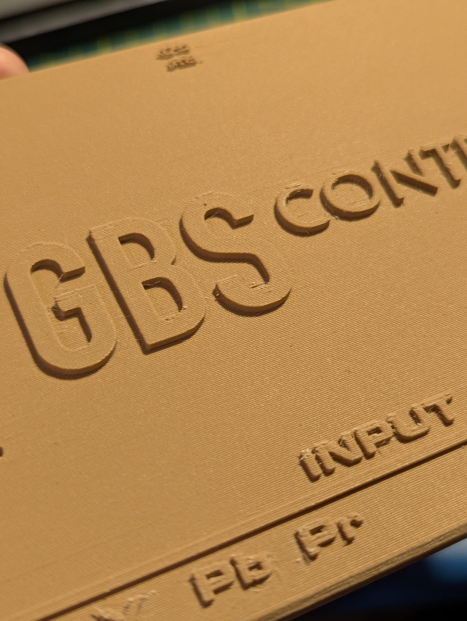 A close-up photograph of the new top plate for the GBS-C enclosure. At this distance, the layer lines are visible.  What you can't tell from a photo is that the texture is similar to that of a new pine board.